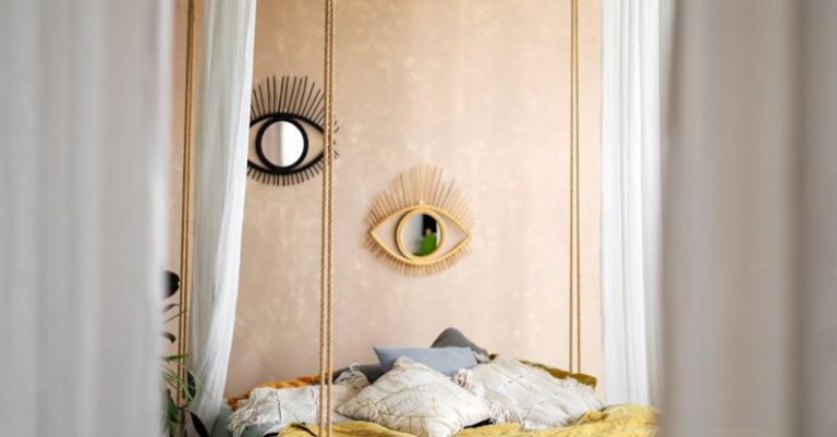 Modern Designs - A bed with a canopy hanging over it in a bedroom