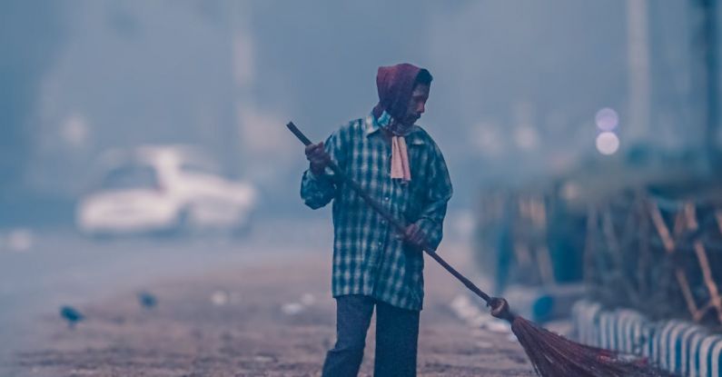 Maintenance Tips - A man sweeping the street with a broom