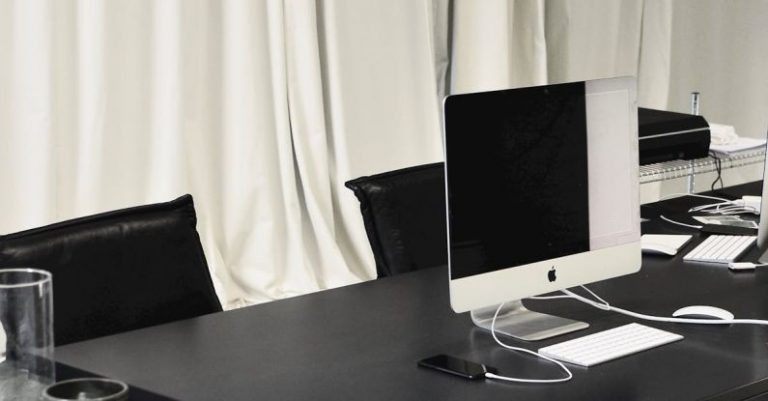 Luxury Properties - Black and white of contemporary computer placed on table in simple contemporary workplace of office